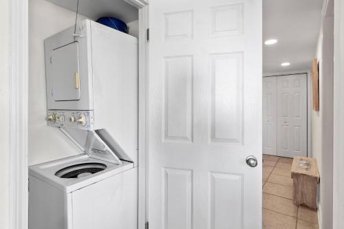 una cocina con lavadora y secadora junto a una puerta en Beachy Keen, en Destin