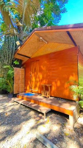 ein Holzhaus mit einer Bank davor in der Unterkunft โฮมสเตย์ เนเจอร์ เดอ สะปัน Nature De Sapan in Ban Huai Ti