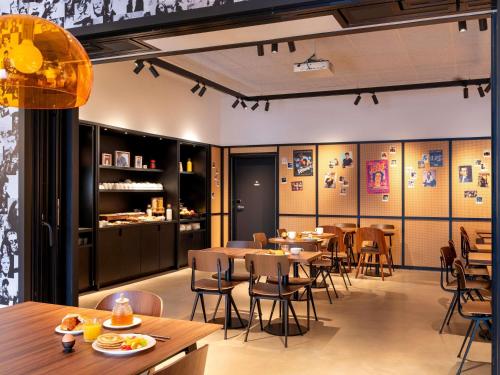 Un restaurante con mesas y sillas en una sala. en ibis Styles Paris Villejuif, en Villejuif