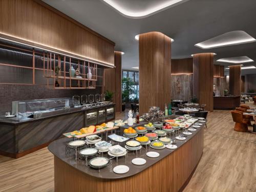 - un buffet avec des assiettes de nourriture dans la cuisine dans l'établissement Mövenpick Living Istanbul Saklivadi, à Istanbul