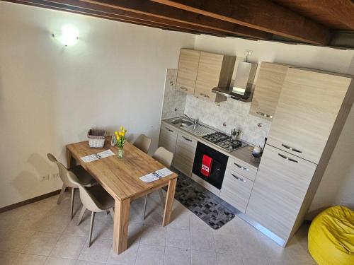 una piccola cucina con tavolo e sedie in legno di MUM & DAD - Loft a Sale Marasino
