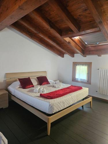 a bedroom with a large bed with red pillows at MUM & DAD - Loft in Sale Marasino