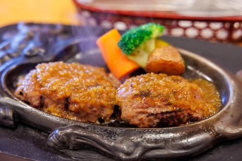 a plate of food with meat and vegetables on a table at Wakihonjin in Kikugawa