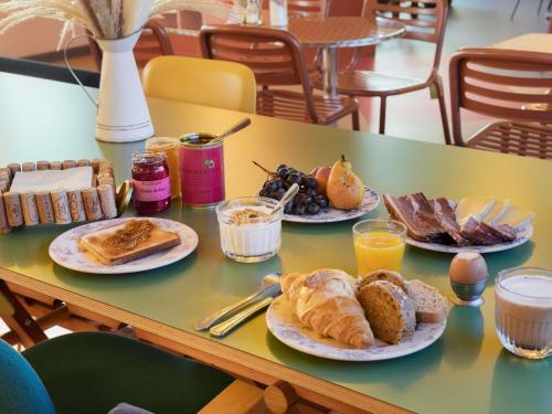 Una mesa con platos de comida para el desayuno. en Greet Hotel Nice Aéroport Promenade des Anglais, en Niza