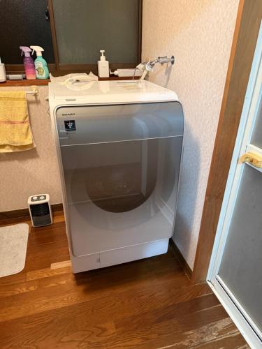 a washing machine sitting on the floor in a bathroom at Guest house 旅人宿ゆるっと in Iburi