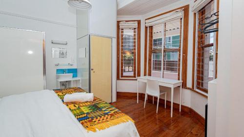 a bedroom with a bed and a table and chairs at Blossom Boutique Guesthouse in Muizenberg
