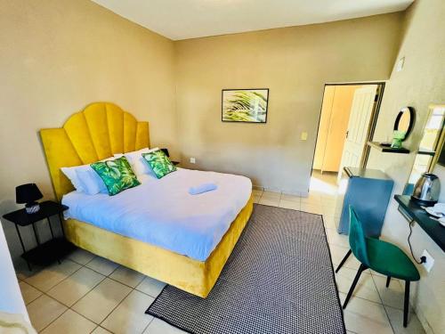 ein Schlafzimmer mit einem großen Bett mit einem gelben Kopfteil in der Unterkunft Grand Inn Hotel-Venda in Thohoyandou