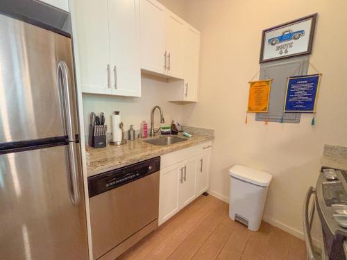 eine kleine Küche mit einem Kühlschrank aus Edelstahl in der Unterkunft Hawaii Oasis 2-Bedroom at The Cove Waikiki condo in Honolulu