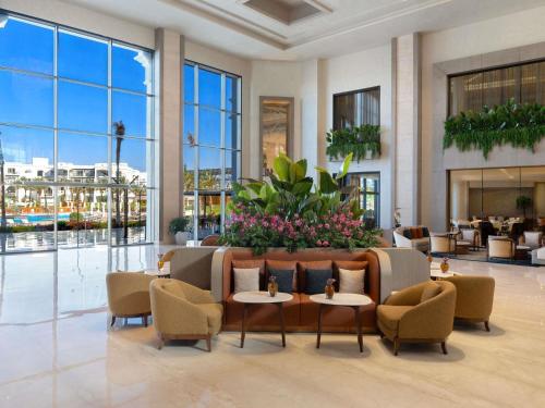 a lobby of a hotel with chairs and tables at Rixos Radamis Sharm El Sheikh in Sharm El Sheikh