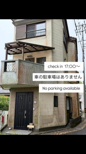 a building with a sign that says check in and no parking vehicles at Guest house 旅人宿ゆるっと in Iburi
