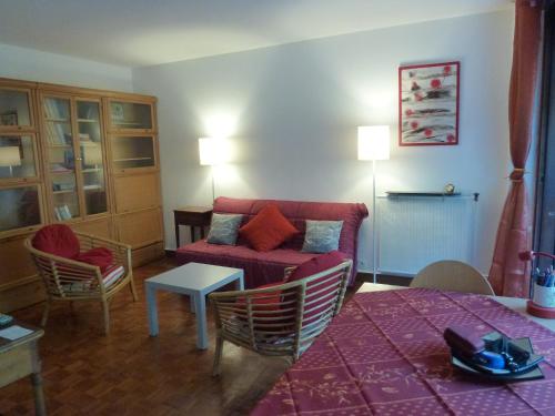 エクス・アン・プロヴァンスにあるApartment Les Muriers Blancsのリビングルーム(赤いソファ、テーブル付)
