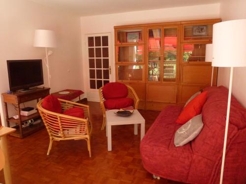 - un salon avec un canapé et des fauteuils rouges dans l'établissement Apartment Les Muriers Blancs, à Aix-en-Provence