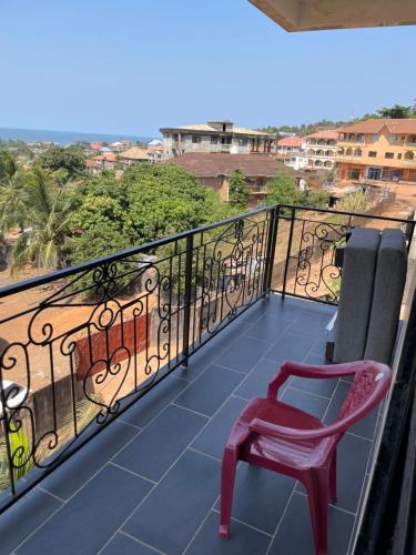 una silla roja sentada en un balcón con vistas en Lovely paradise, en Pendembu
