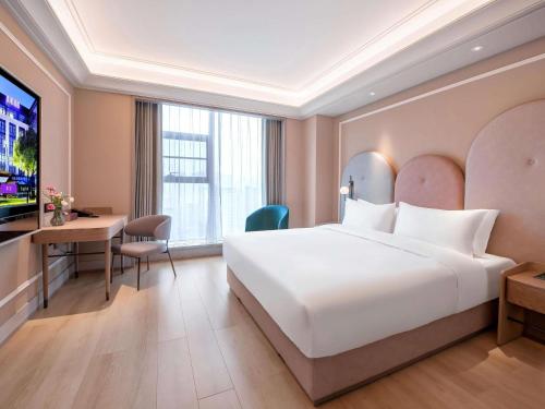 a hotel room with a bed and a desk at Mercure Chengdu Longtan in Chengdu