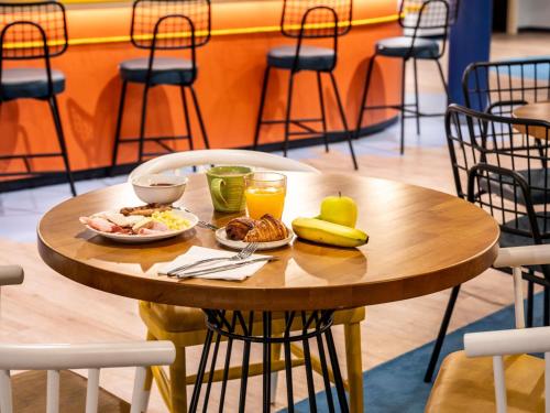 Una mesa con alimentos y bebidas para el desayuno. en ibis budget Morlaix, en Morlaix