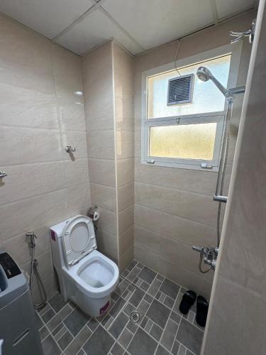 a small bathroom with a toilet and a window at Studio room in Al ain in Al Ain