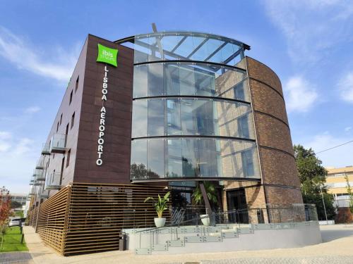 a tall glass building with a sign on it at ibis Styles Lisboa Aeroporto in Lisbon