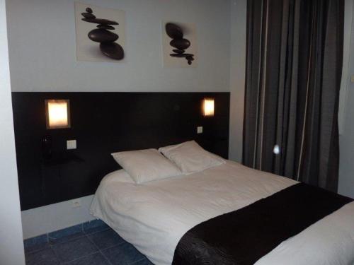 ボーソレイユにあるホテル ヴィラ ボエリのベッドルーム(白いベッド、黒いヘッドボード付)