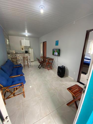 a living room with blue chairs and a table at Casa Azul, à 50m da Praia, Ilha dos Frades - Ponta de Nossa Senhora in Salvador