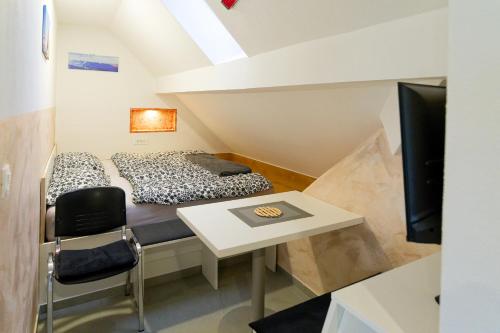 une chambre avec un lit, une table et une télévision dans l'établissement Flegarrooms, à Cerklje na Gorenjskem