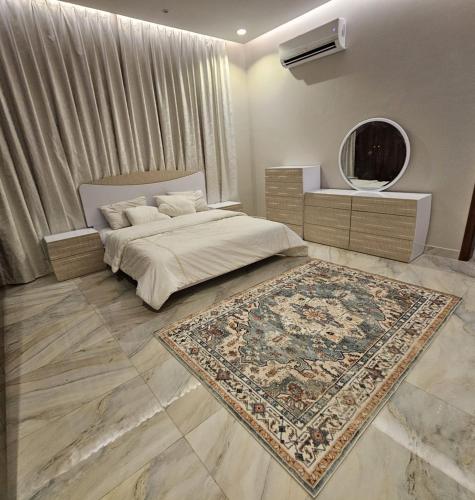 a bedroom with a bed with a rug and a mirror at استراحة الزهراء in Jeddah