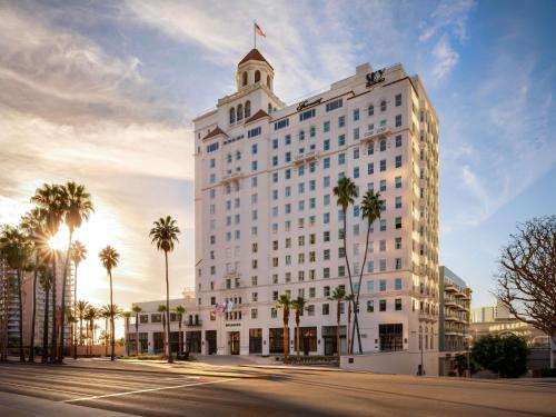 a large white building with palm trees on a street at Fairmont Breakers Long Beach in Long Beach