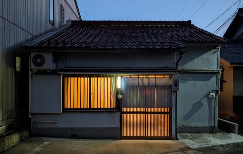 a house with a gate and a door with lights at 最大5名 平屋一軒家貸切 駐車場2台無料 ファミリーやグループに最適 in Gifu