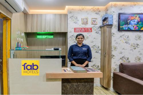Una mujer parada detrás de un mostrador en una habitación. en FabHotel Royal Rose Residency, en kolkata