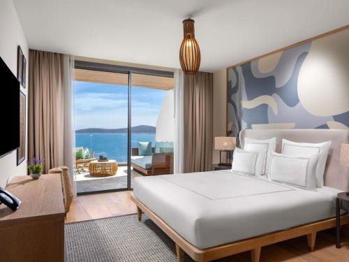 ein Schlafzimmer mit Bett und Blick auf das Meer in der Unterkunft Swissôtel Living Bodrum in Bodrum City