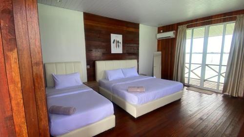 une chambre avec deux lits et une fenêtre dans l'établissement Sea Plus Water Challet, à Semporna