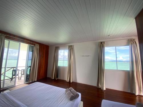 a bedroom with a bed with a view of the ocean at Sea Plus Water Challet in Semporna