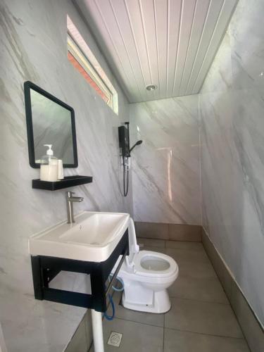 a bathroom with a sink and a toilet at Sea Plus Water Challet in Semporna
