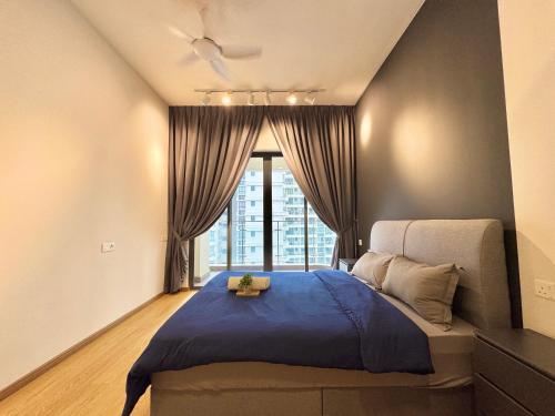 ein Schlafzimmer mit einem Bett mit blauer Bettdecke und einem Fenster in der Unterkunft Kingsbay Danga Bay Country Garden by Luxecocoo CK in Johor Bahru