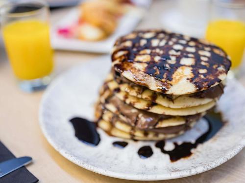 a stack of pancakes on a plate on a table at Novotel Valencia Lavant in Valencia