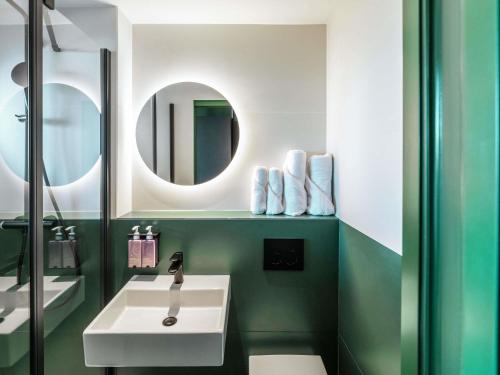 a bathroom with a white sink and a mirror at TRIBE Paris Clichy in Clichy