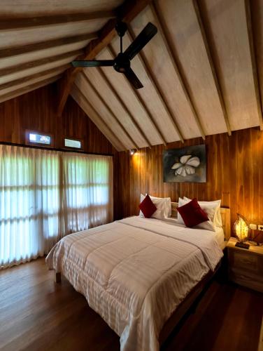 a bedroom with a large bed with a ceiling fan at Tetebatu Flush Harmony in Tetebatu