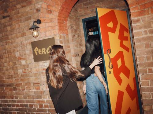 deux femmes debout devant un miroir dans l'établissement Hotel Woolstore 1888, Sydney - Handwritten Collection, à Sydney
