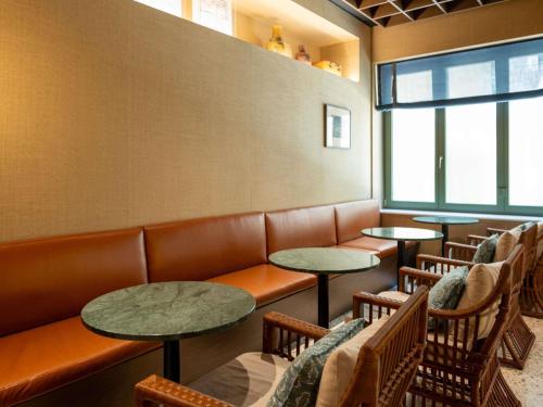 アテネにあるAthens Capital Suites-MGallery Collectionのテーブルと椅子が2つある待合室