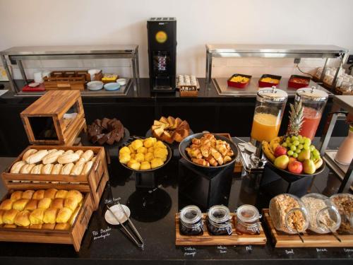 Un buffet con diferentes tipos de comida en una mesa. en Ibis Serra Talhada, en Serra Talhada