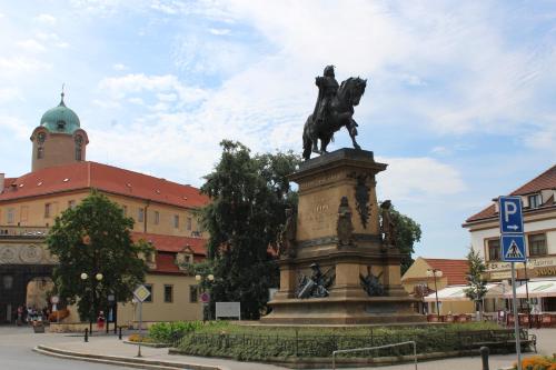 a statue of a man riding a horse in front of a building at Apartment Promenada in Poděbrady