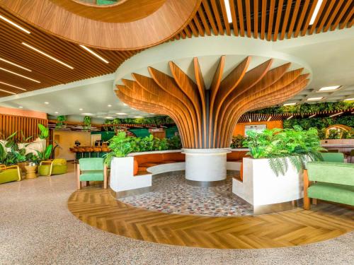 a lobby with plants and a large tree at ibis Styles Istanbul Kurtkoy in Istanbul