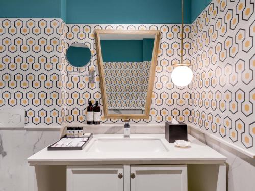 un baño con lavabo y espejo en Grand Mercure Goa Candolim - An Accor Hotels Brand, en Candolim