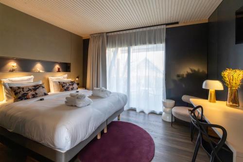 Un dormitorio con una cama grande con dos animales de peluche. en James Vignoble Hôtel, Eguisheim, en Eguisheim