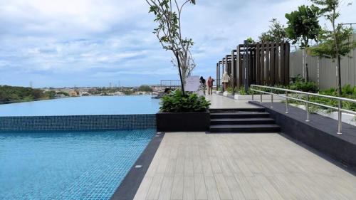 a pool of water with people walking around it at AL Homestay with 3 Bedrooms in Alor Setar