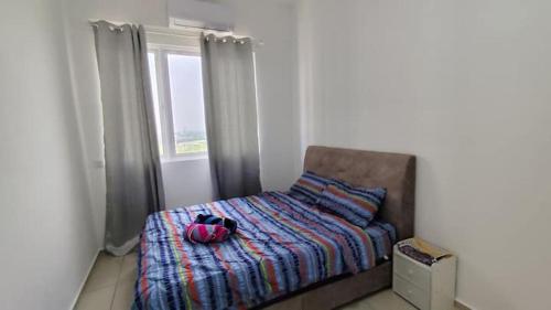 a bedroom with a bed with a backpack on it at AL Homestay with 3 Bedrooms in Alor Setar