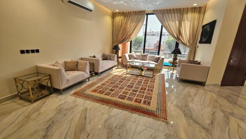 un ampio soggiorno con divani e un tappeto di استراحة الزهراء a Gedda