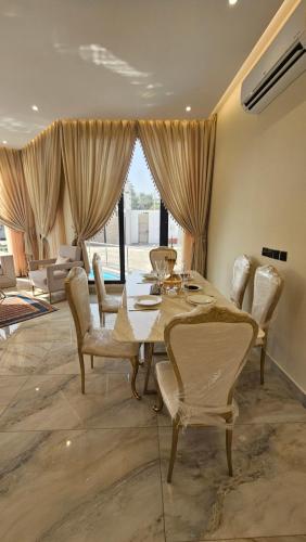 una sala da pranzo con un lungo tavolo e sedie di استراحة الزهراء a Gedda