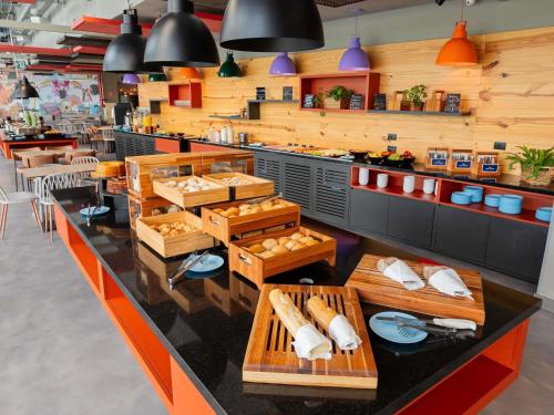 un restaurante con una barra con mesas y sillas en Ibis Budget Guarulhos Aeroporto, en Guarulhos