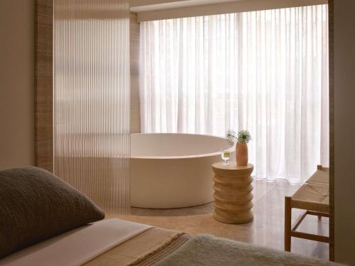 a bath tub in a bedroom with a window at Mondrian Gold Coast in Gold Coast