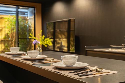 una mesa con platos y cuencos y cucharas en ella en 難波站走路8分鐘包棟別墅 絕佳地理位置 最大16人, en Wada